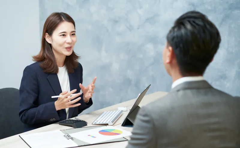ノートパソコンを前に向かい合って打ち合わせをする男女